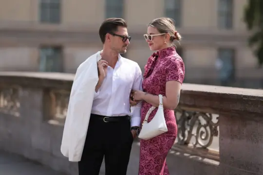 Elegancka para, inspiracja, jak się ubrać na poprawiny: on w białej koszuli i czarnych spodniach, ona w różowej sukience w róże.