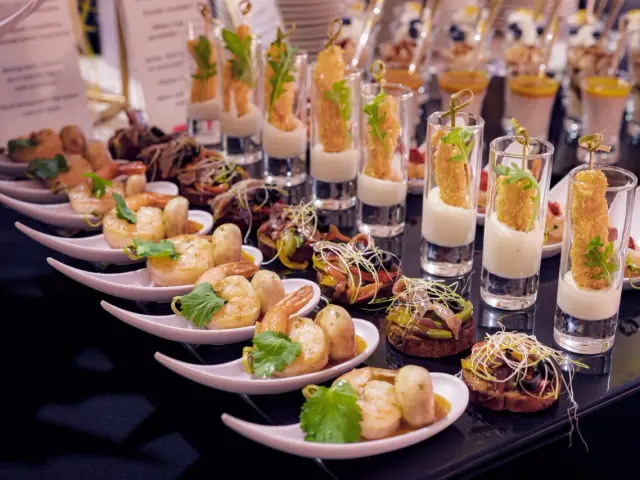 Elegancki catering na wesele: krewetki, mini kanapeczki i przekąski w kieliszkach.