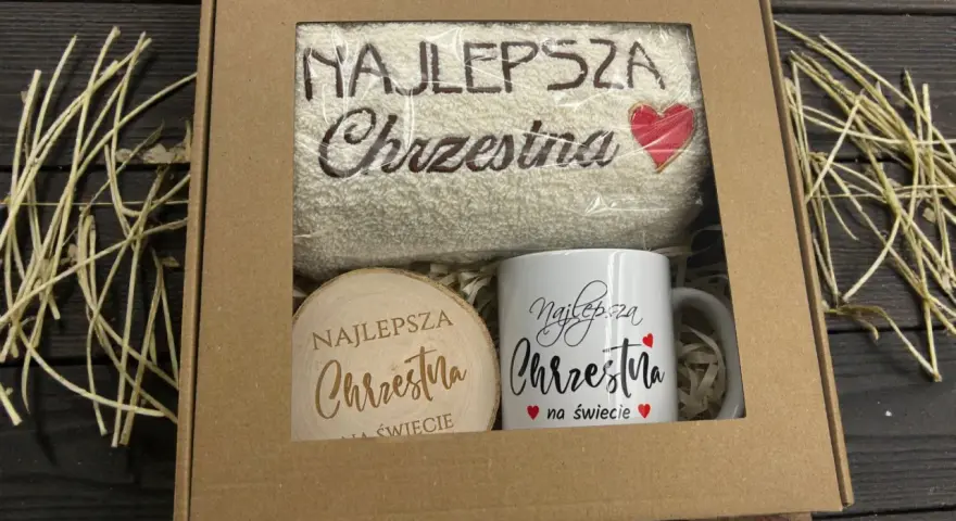 Prezent dla najlepszej chrzestnej: ręcznik z haftem i kubek z napisem "Najlepsza Chrzestna na świecie".